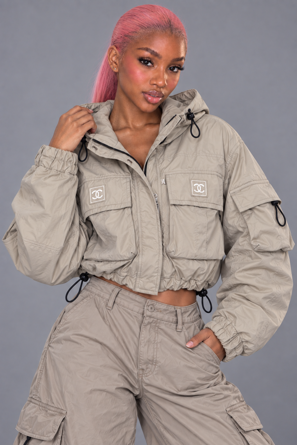 Femme portant une veste cargo courte gris taupe avec capuche et grandes poches